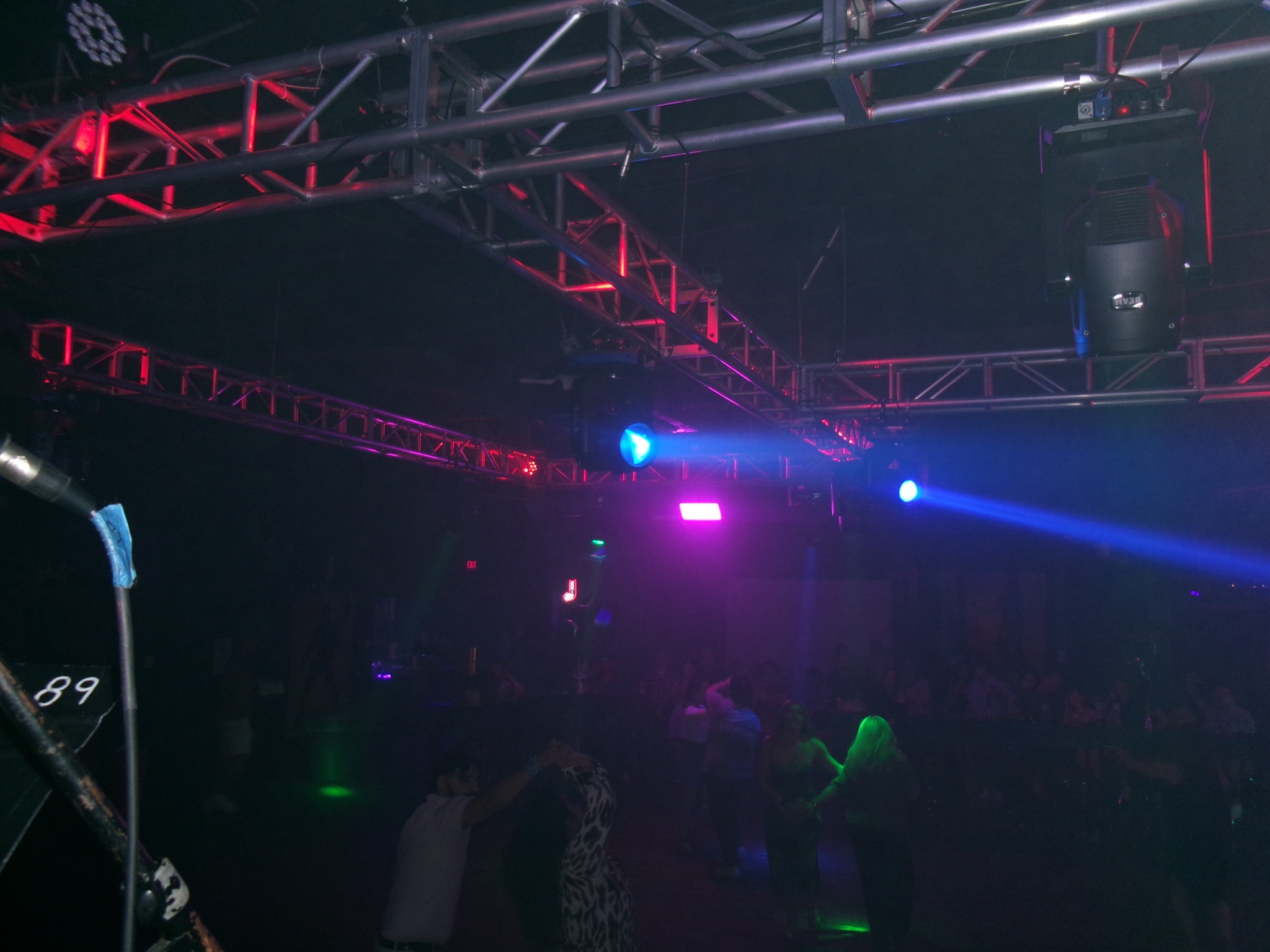 A nightclub dance floor illuminated by colorful stage lights