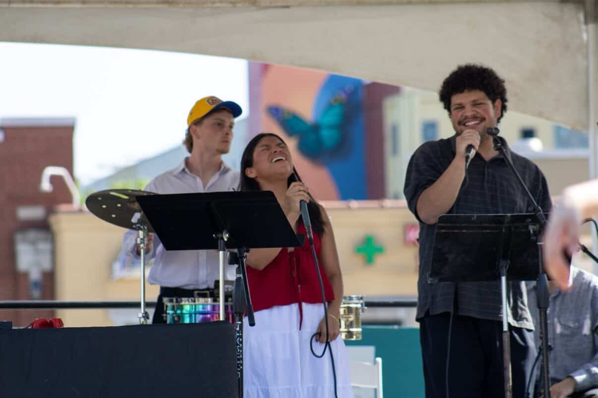 Orquesta Afinke vocalists smiling during an outdoor performance
